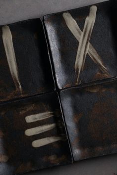 four pieces of black leather with white paint on them and forks sticking out of it