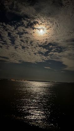 the moon is shining brightly over the water