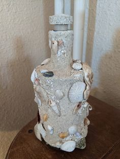 a candle holder with shells and seashells on it