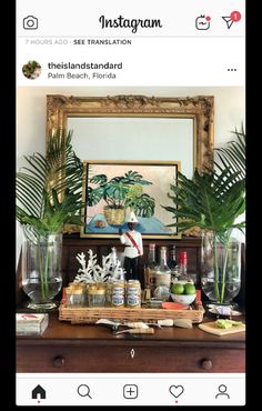 a wooden dresser topped with vases filled with plants and bottles on top of it