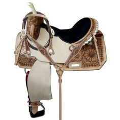 a white and brown horse saddle with black accents on the front, beige bridle and reins