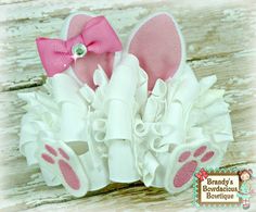 a pair of pink and white baby booties with bows