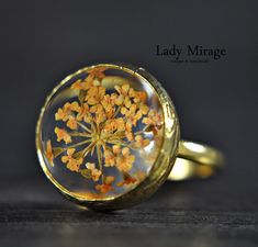 The ring was made with real flowers which was cast in glass-like resin.  The cheerful peach color reminds you of sunny autumn days. In keeping with the warm tone, the ring is adorned with a gold-plated setting. It can be combined with any outfits, whether chic, classic or in everyday life. What is certain is that you will attract attention! You can find the matching earrings and bangle in our shop under the following link: https://www.etsy.com/de/listing/834017216/echte-bluten-ohrringe-peach-vergoldet?ref=shop_home_active_3&frs=1 https://www.etsy.com/de/listing/847921319/echte-bluten-armreif-peach-vergoldet?ref=shop_home_active_1&frs=1 Size: adjustable and fits every finger ! Flower's Cabochon : 1,6 cm ♥ Handmade with Love Lady Mirage is a designer jewelry label from Berlin. We manufacture Nature-inspired Gold Flower Ring, Gold Flower Ring Nature-inspired, Gold Nature-inspired Flower Ring, Gold Flower-shaped Nature-inspired Rings, Vintage Resin Rings For Gifts, Peach Ring Jewelry Gift, Gold Rings With Pressed Flowers For Wedding, Handmade Gold Flower Ring Nature-inspired, Gold Resin Rings As A Gift