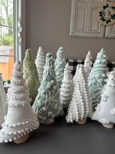 small white christmas trees are lined up on a table