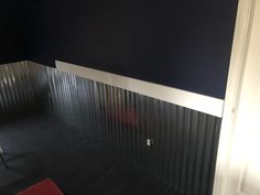 an empty room with black walls and white trim on the bottom half of the wall