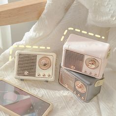 an old fashioned radio sitting on top of a bed next to a cell phone