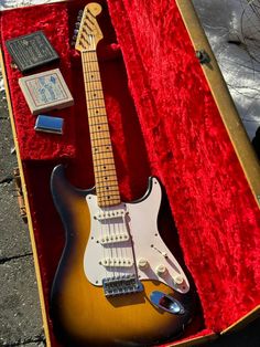 an electric guitar in a case on the ground