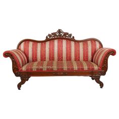 an old fashioned couch with red and white striped upholstered fabric on the back