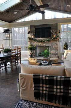 a living room filled with furniture and a flat screen tv mounted to the wall above a fireplace