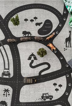 a blanket with cars and trees on it next to wrapping paper, scissors and other items