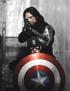 a man holding a camera next to another man in a captain america costume and shield