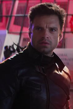 a man in a leather jacket looking at the camera