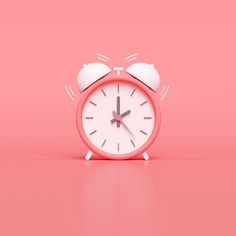 an alarm clock on a pink background