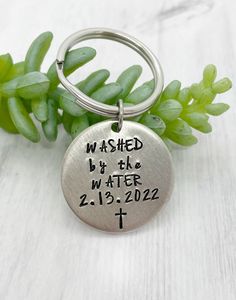 a metal keychain with the words washed by the water on it