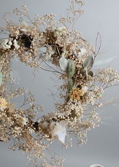 a wreath with dried flowers and leaves on it