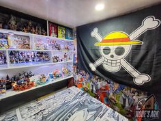 a bedroom with a pirate themed bed and shelves full of action figures on the wall