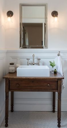 a bathroom with a sink, mirror and toilet in it's centerpieces