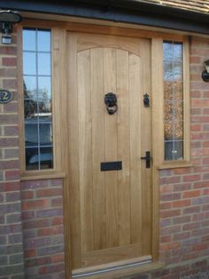 a wooden door with two sidelights on the outside of a brick building and glass windows