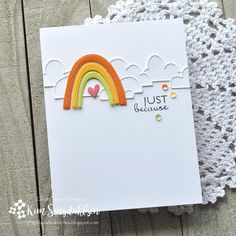 a card with a crochet doily on it and a rainbow in the background