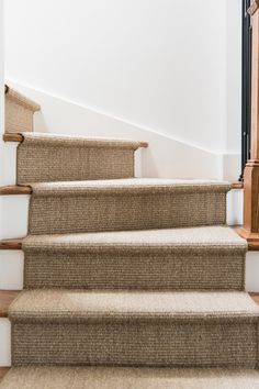 the carpeted stairs are lined with wooden handrails