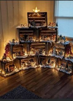 a christmas tree made out of wooden crates with lights on them and decorations around it