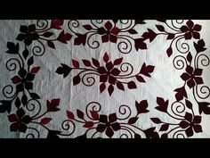 a white and red table cloth with floral designs on the edges, along with an intricately designed border