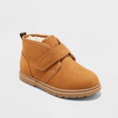 Prepare your little one for back-to-school and winter adventures with these Magnus Boots from Cat & Jack™. These closed-toe boots have a faux-suede upper in a versatile cognac shade, contrasted with a white faux-shearling insole and lining. Set on a flocked outsole, these medium-width boots are finished with an adjustable strap featuring a hook-and-loop closure on the front for a customizable fit. Cat & Jack™: Designed for all children so you can trust it's made for yours. Winter Scratch-resistant Boots With Round Toe, Fall High-top Boots For School, Casual School Boots For Fall, School Boots For Fall With Round Toe, Casual Winter Boots For School, Casual Winter School Boots, Faux Suede Boots, Rubber Boot, Footbed Sandals