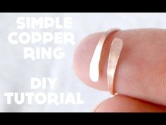 a hand holding a ring with the words simple copper ring on it