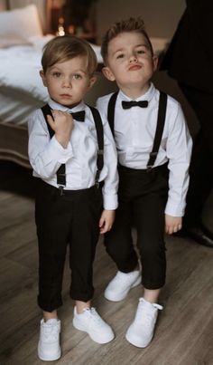 two young boys dressed in black and white tuxedos