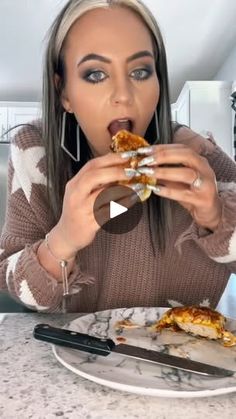 the woman is eating pizza at the table