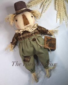 an old fashioned scarecrow doll with a sign