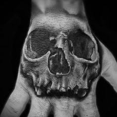 a black and white photo of a hand with a skull on it