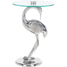 a glass table with a metal flamingo standing on it's legs and feet