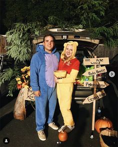 a man and woman in costumes standing next to a car