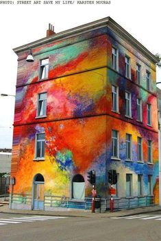 a large multicolored building on the corner of a street in front of a traffic light