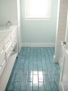 a bathroom with blue tile floors and white fixtures