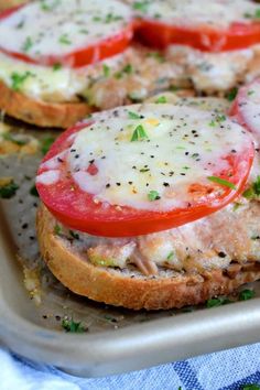 an open face sandwich with tomatoes, cheese and herbs on the top is ready to be eaten