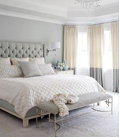 a bedroom with a large bed and chandelier