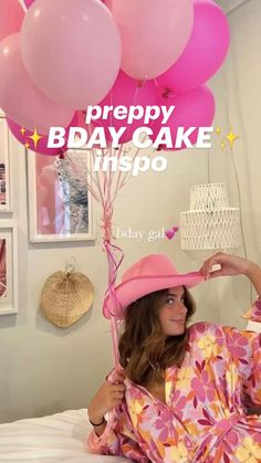 a woman laying on top of a bed wearing a pink hat and robe with balloons