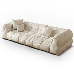 a large white couch with pillows on it's back and two throw pillows in the middle