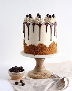 a cake with white frosting and chocolate drizzles