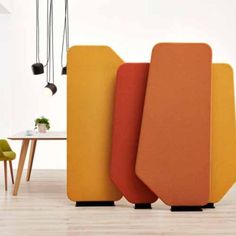 an orange and yellow couch sitting in front of a table with two chairs next to it