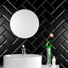 a white sink sitting under a mirror next to a wall mounted faucet in a bathroom