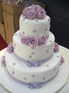 a three tiered cake with purple flowers on it