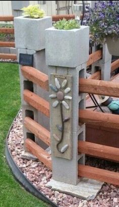 a cement planter in the shape of a flower on top of a wooden fence