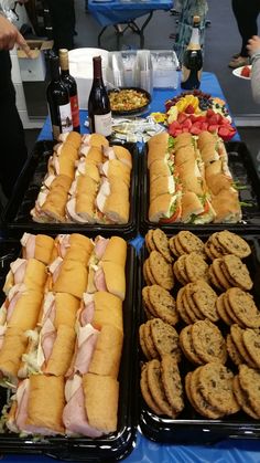 several trays filled with sandwiches on top of a table