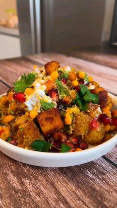 a white bowl filled with food on top of a wooden table