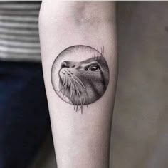 a cat tattoo on the left forearm and right arm, with an animal's head in