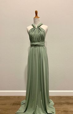 a dress on a mannequin in front of a white wall and wooden floor