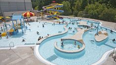 an outdoor swimming pool with water slides and children playing in it